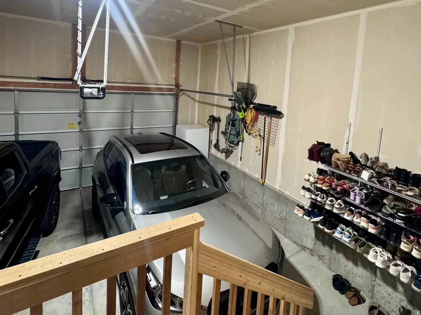 Two-car garage featuring exposed drywall, concrete flooring, and an overhead garage door