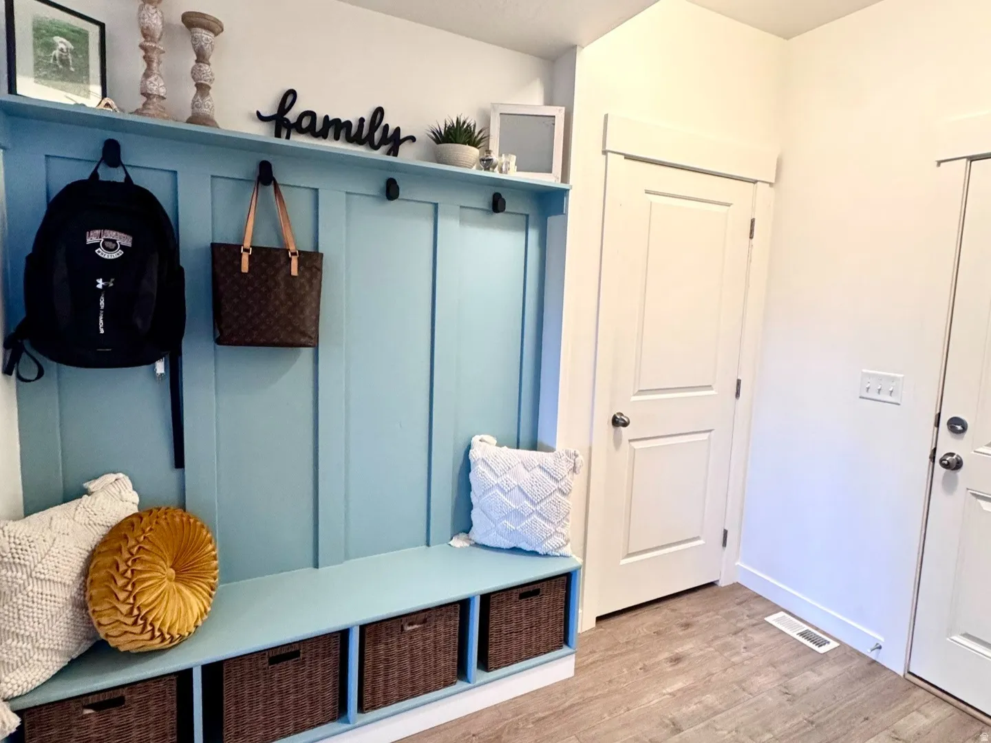 Built-in entryway bench with integrated storage cubbies and wall-mounted hooks