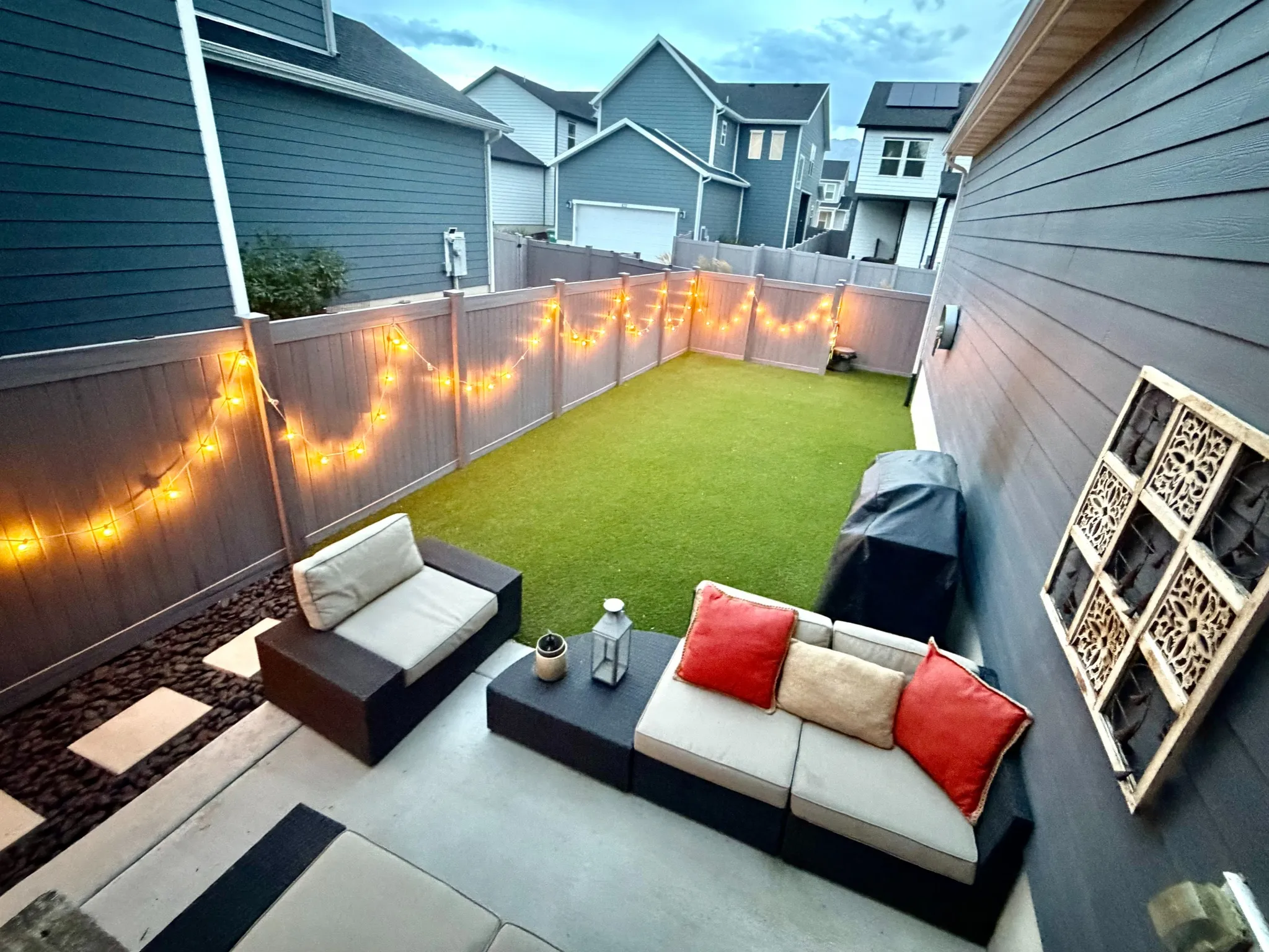 Private outdoor space featuring a paved patio and a fenced yard with artificial turf