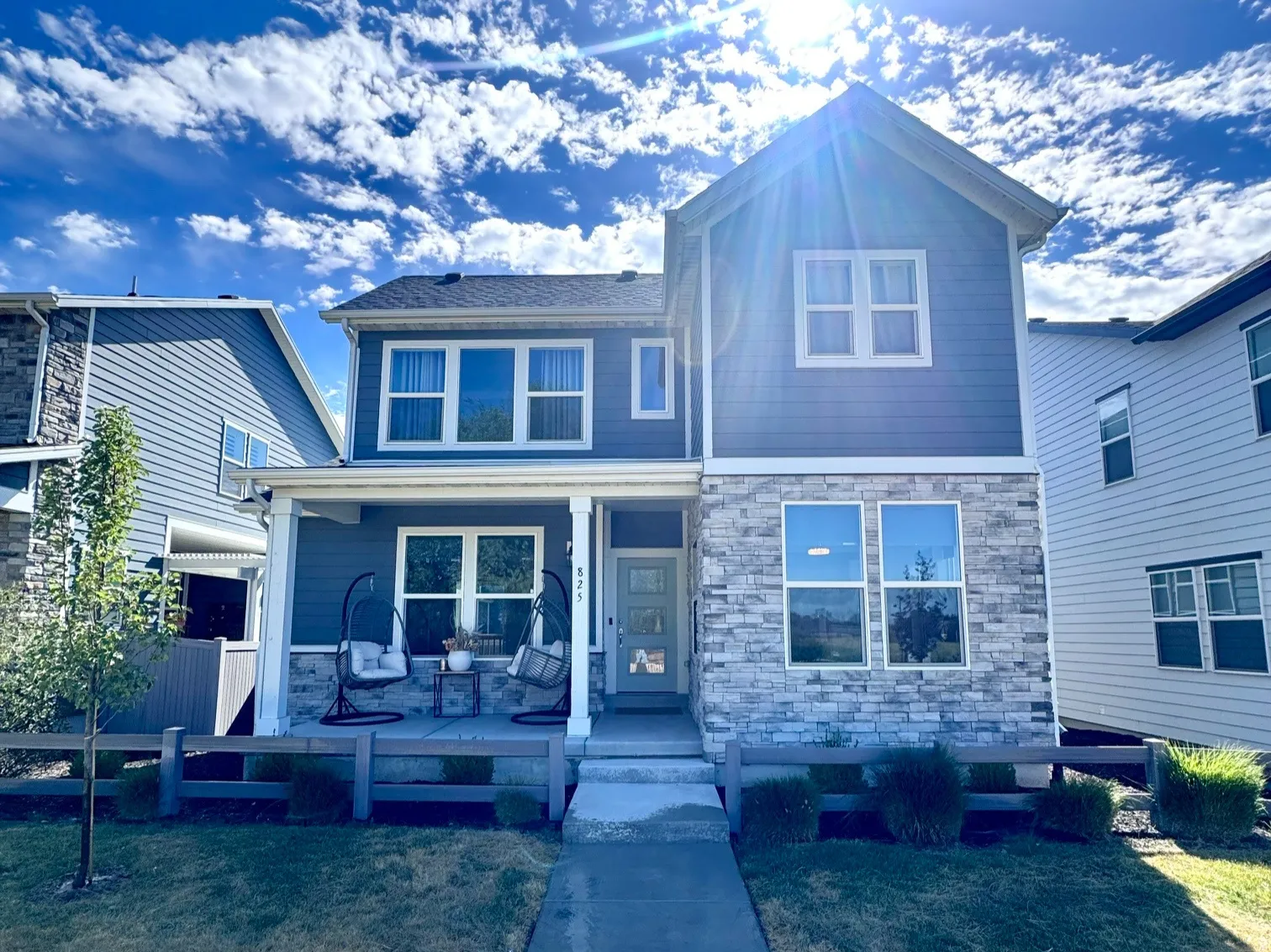 Two-story residence featuring a blue siding and stone facade