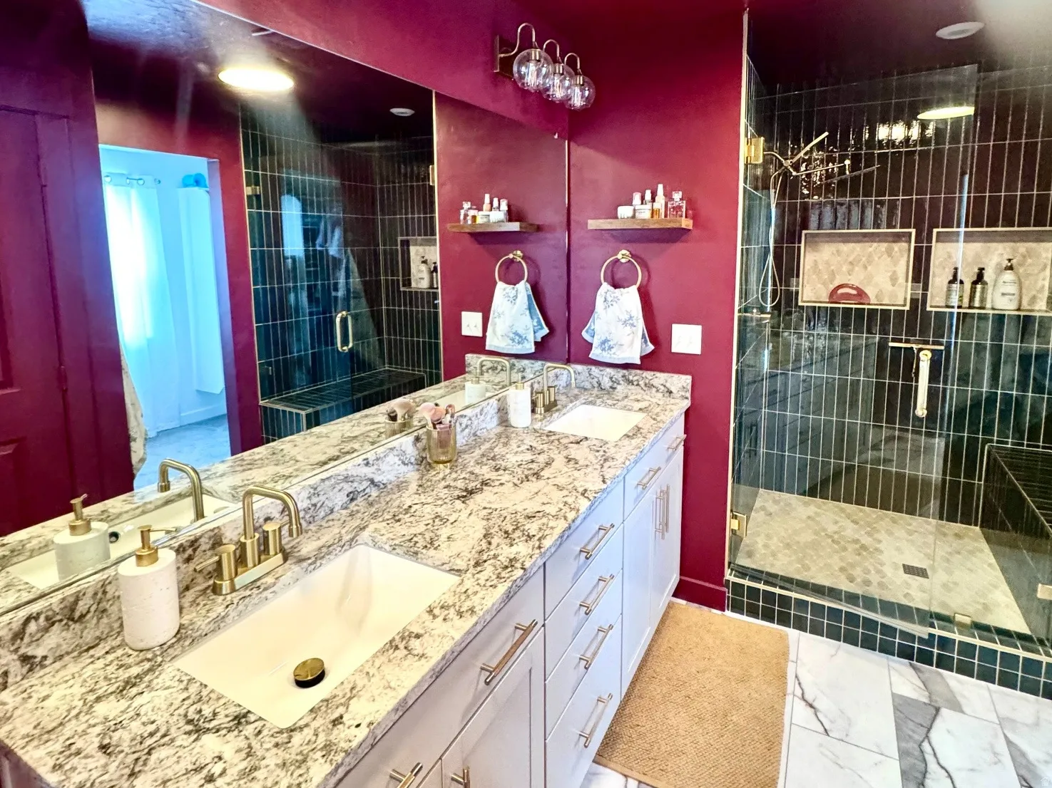 Dual vanity with white cabinetry, gold-finish hardware, and a speckled countertop