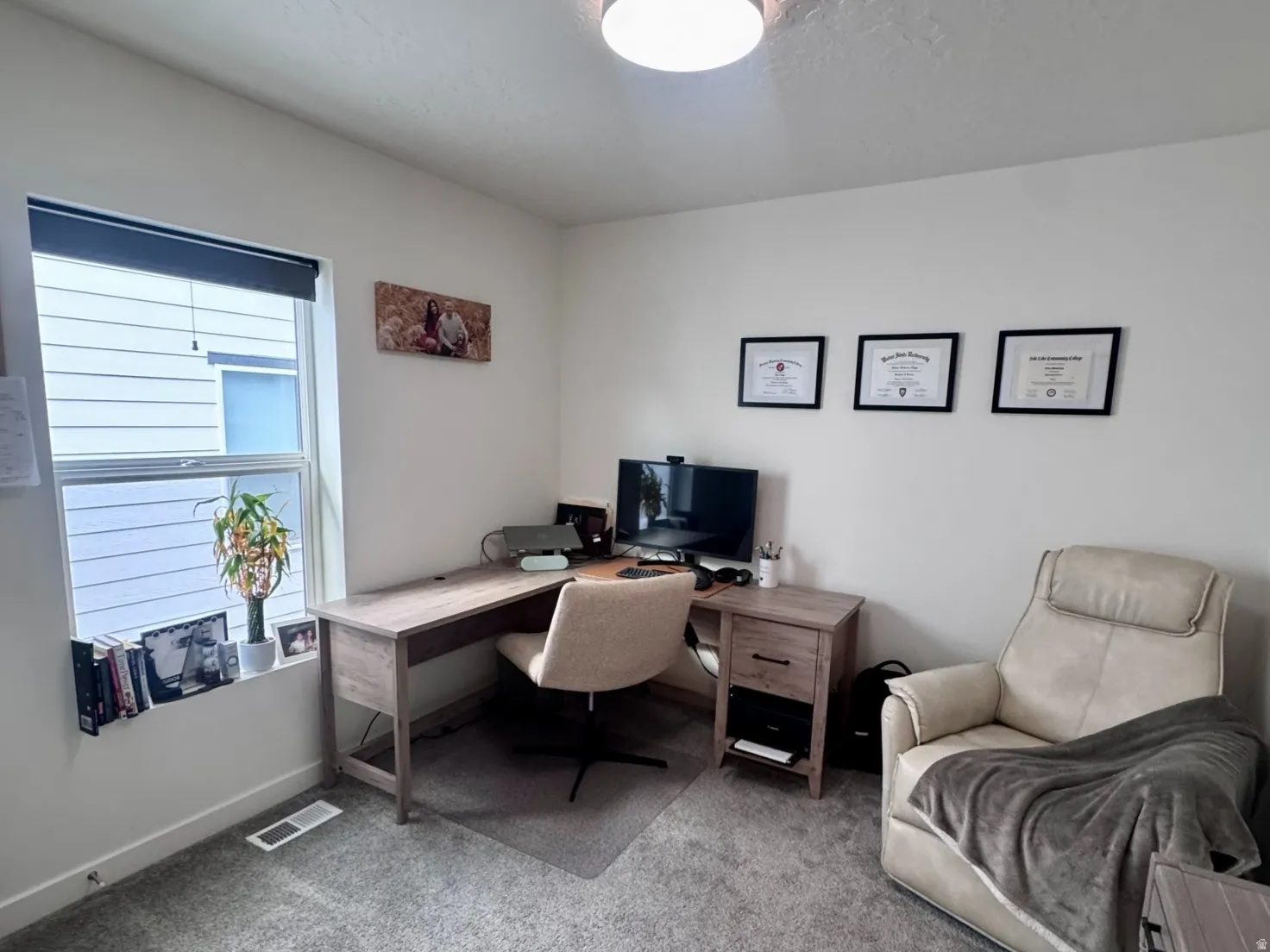 Carpeted room featuring a light-colored wall finish, a window with blinds, and a flush-mount ceiling light fixture