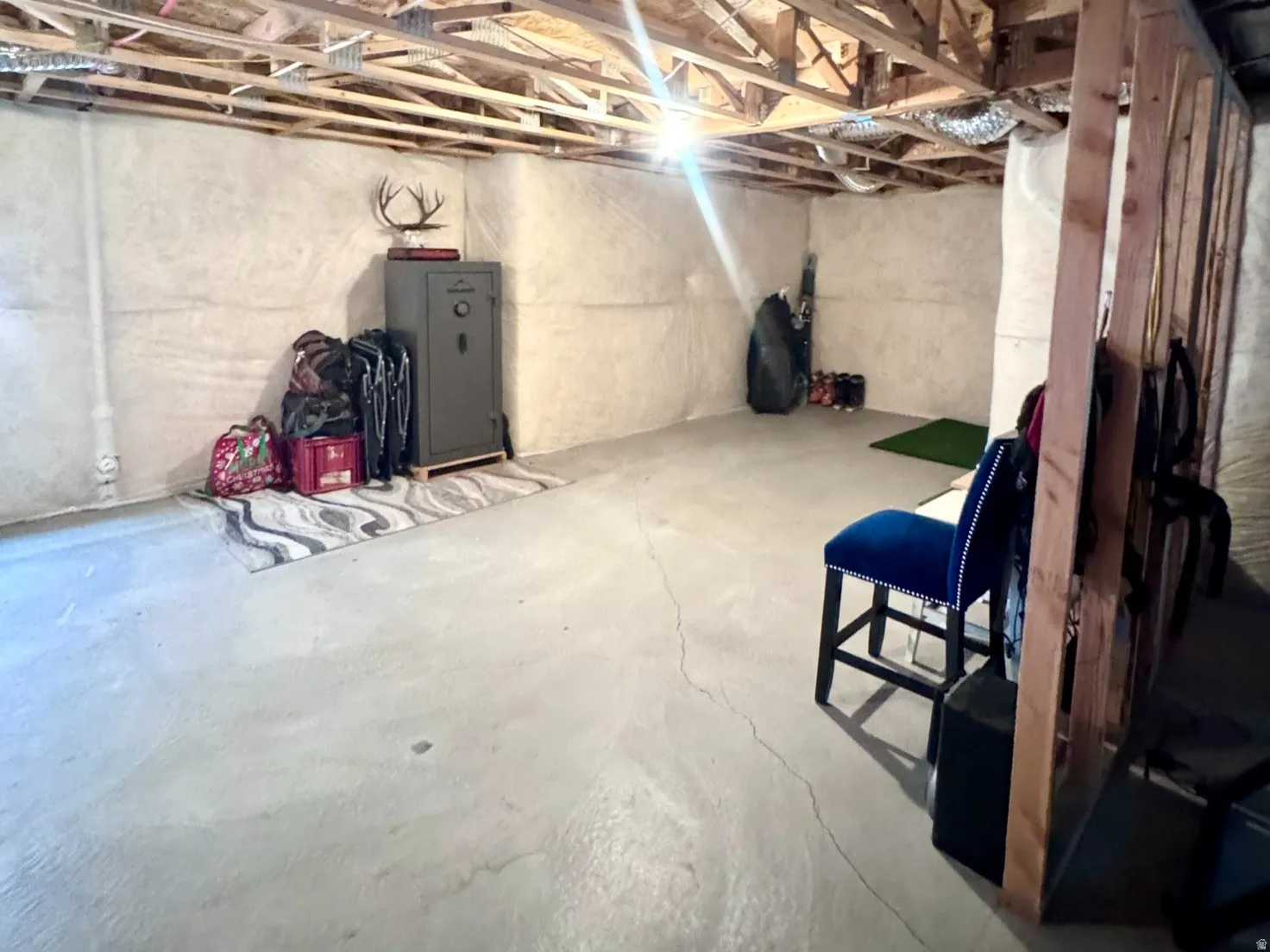 Unfinished basement featuring exposed wood ceiling joists and concrete flooring