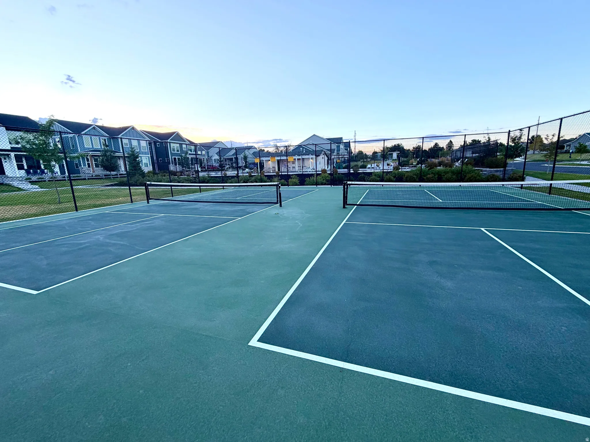 Community courts featuring green and blue surfacing, white court lines, and black nets