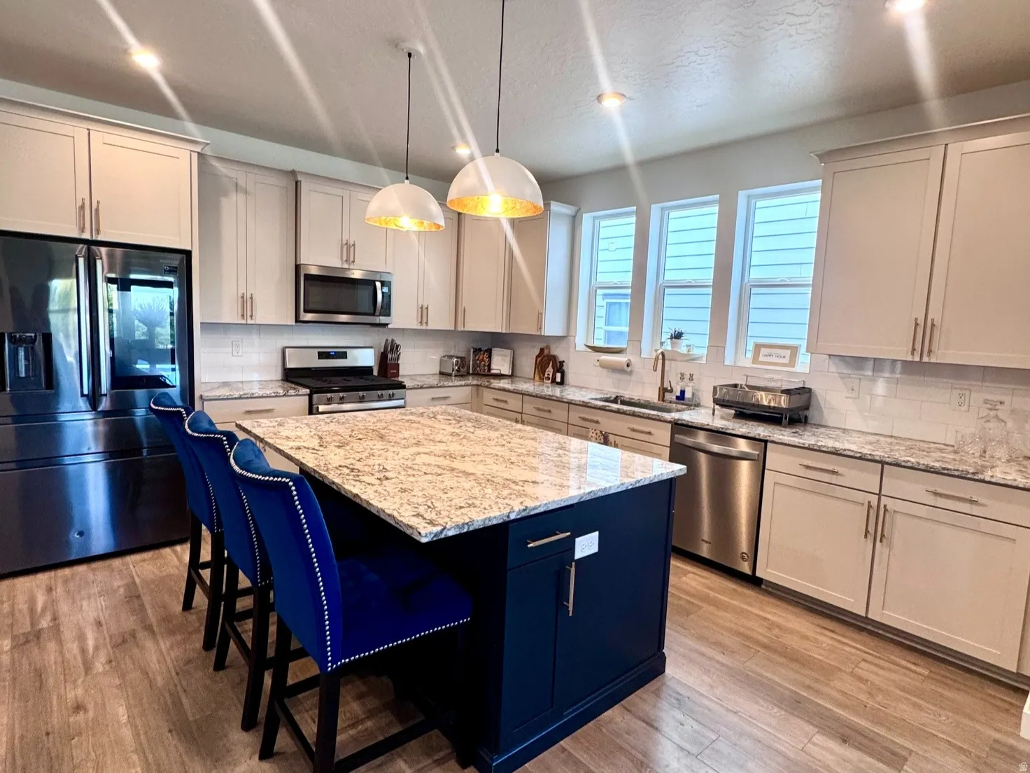 Kitchen featuring a spacious island with a granite countertop and blue base cabinetry
