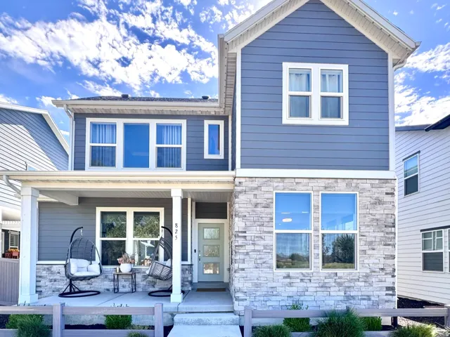 Two-story residence featuring a blue siding exterior with stone facade accents