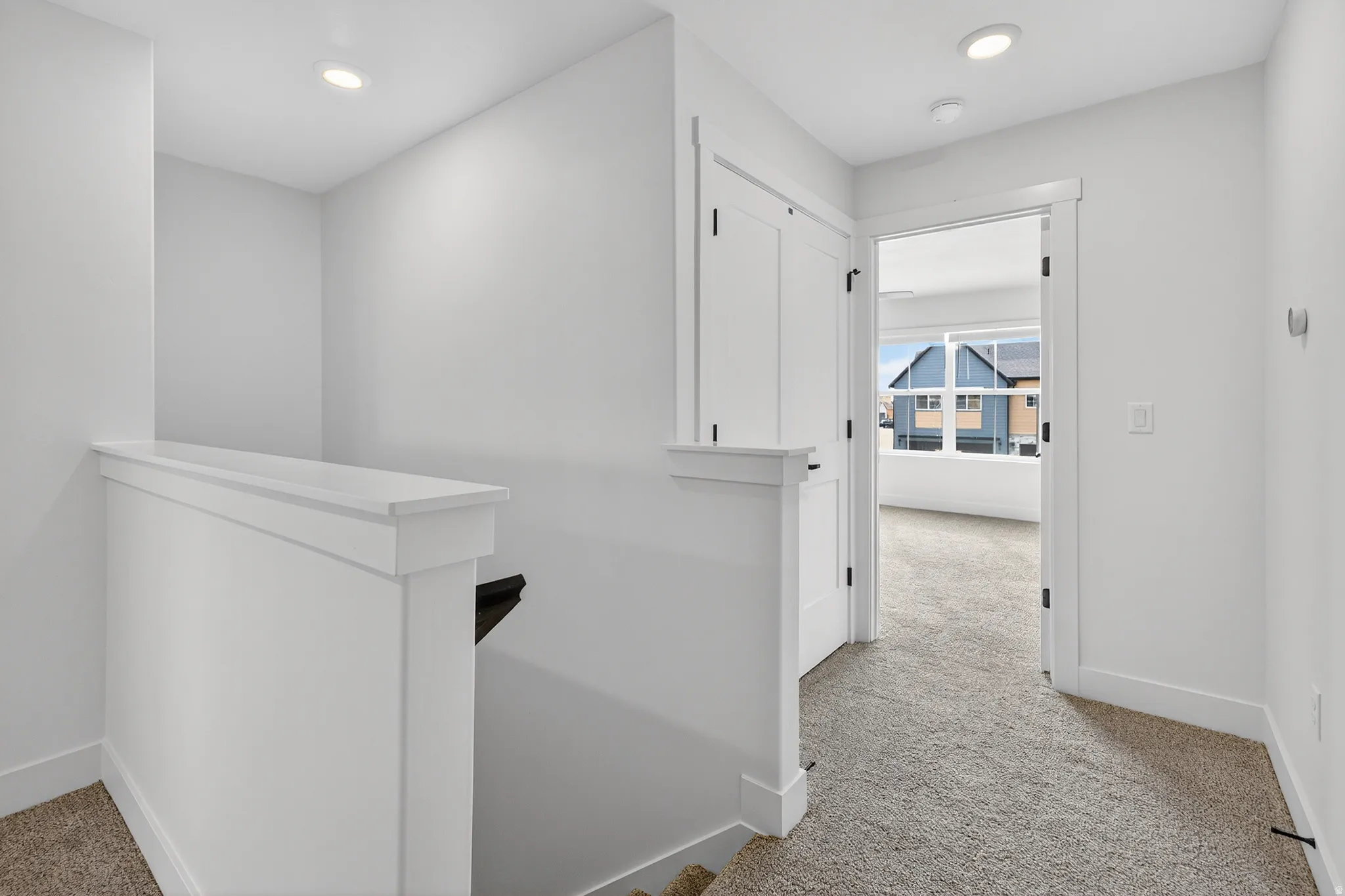 Upper-level hallway featuring plush carpet flooring and recessed lighting