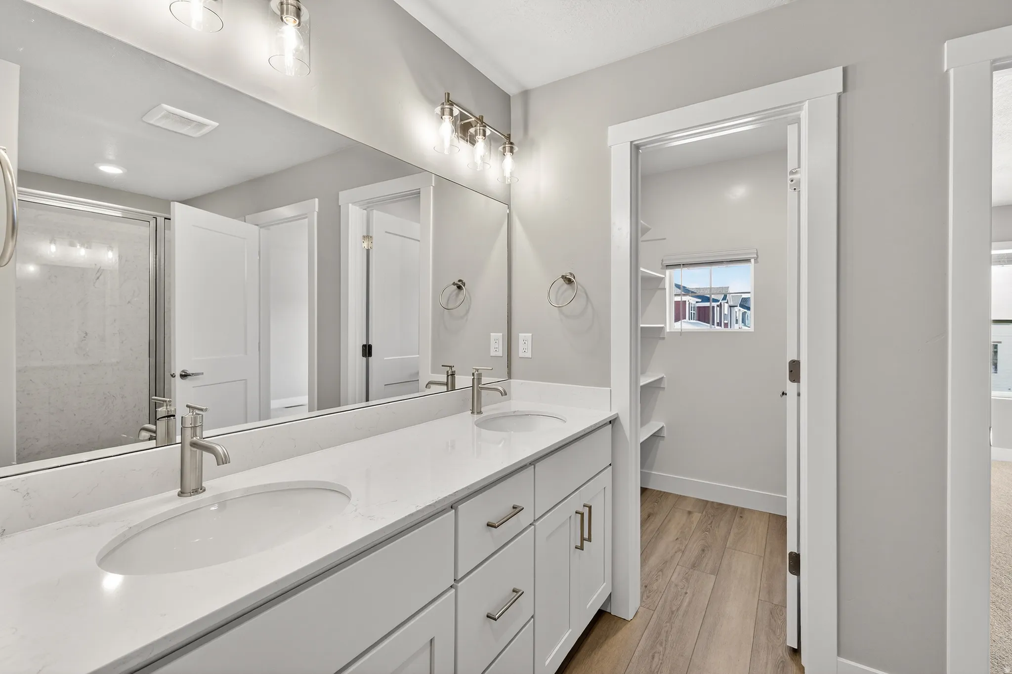 Double vanity featuring undermount sinks, stone countertops, and brushed nickel fixtures