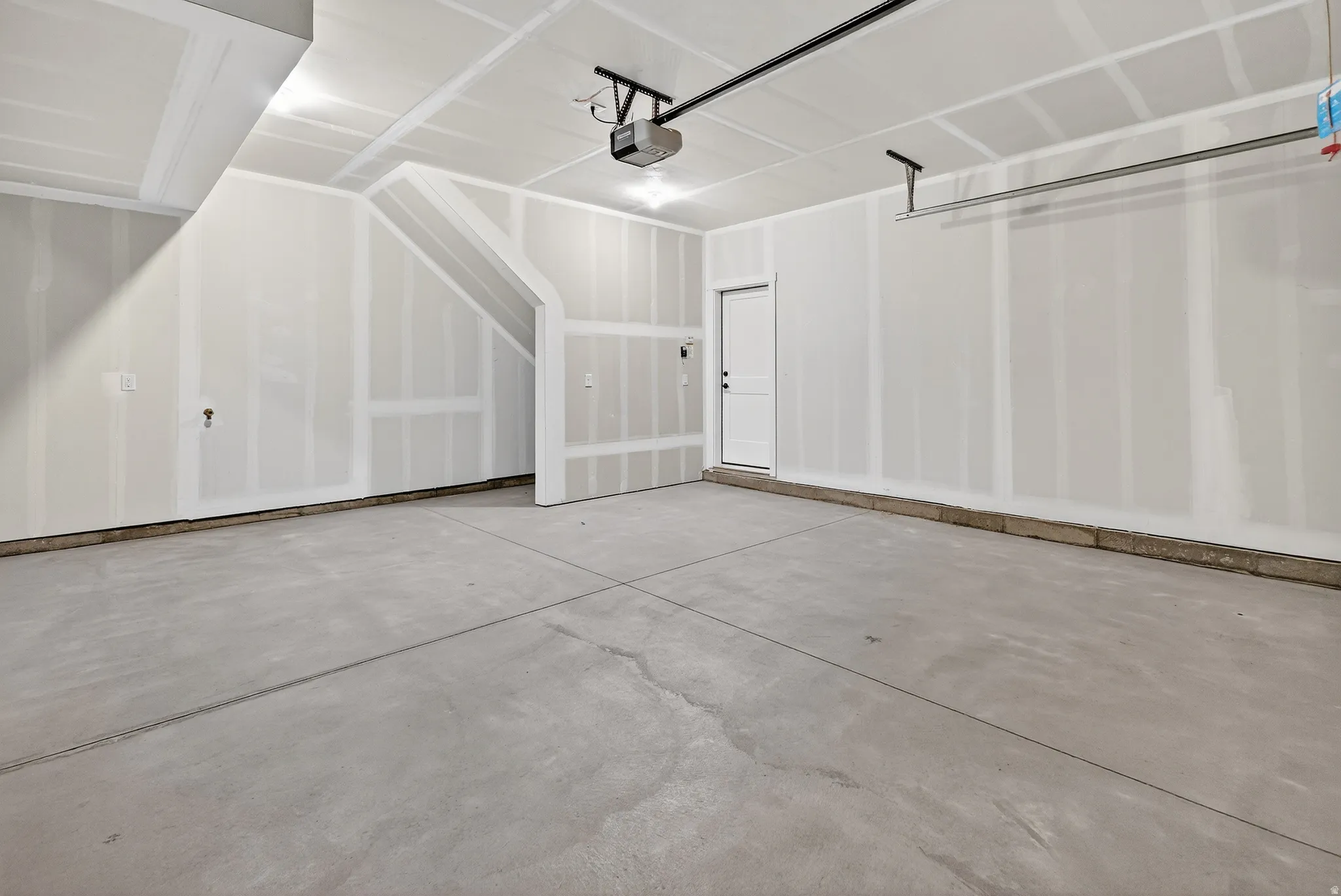 Spacious garage featuring a concrete floor, high ceilings, and an interior access door