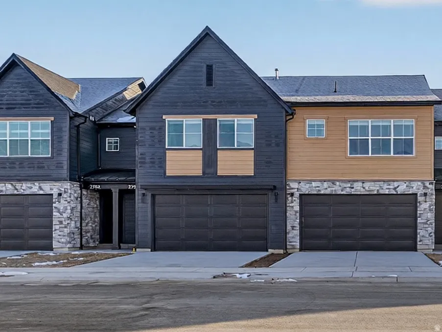 Modern townhome-style residences featuring dark-toned siding and light-colored accent panels