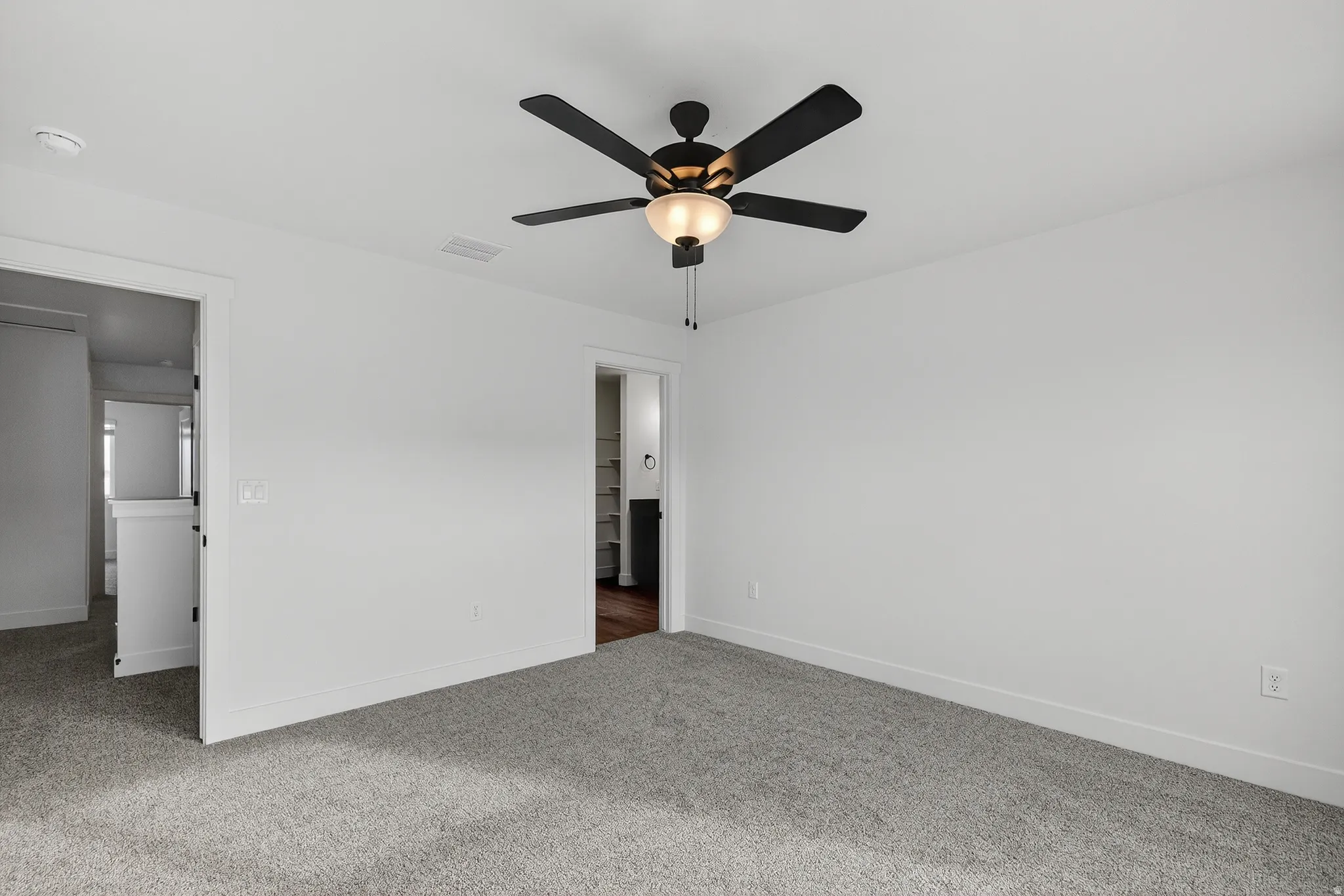 Spacious room featuring neutral carpeting and crisp white walls