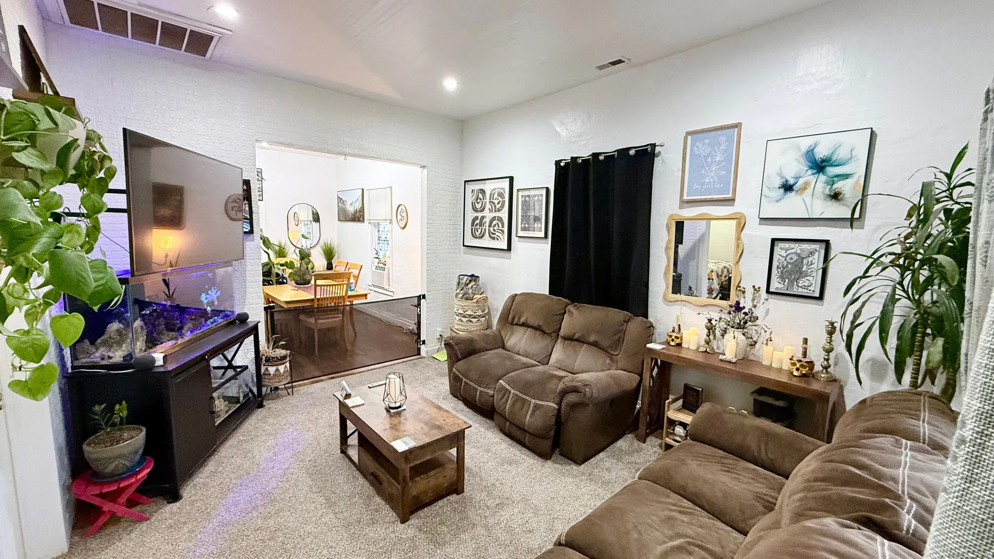 Spacious living area featuring neutral carpeting and white walls