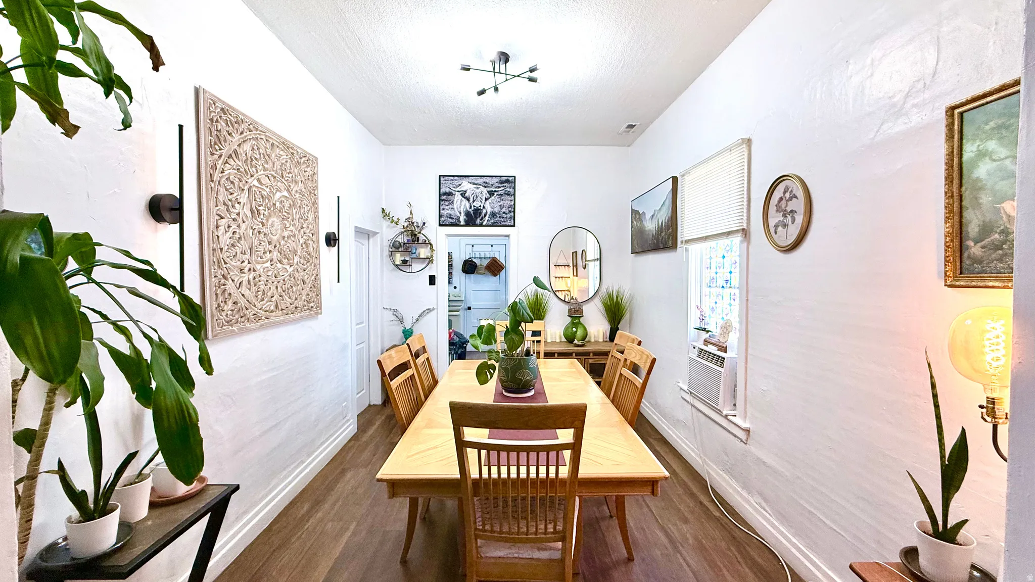 Dining area featuring wood-finish flooring, white painted walls, and a ceiling-mounted light fixture