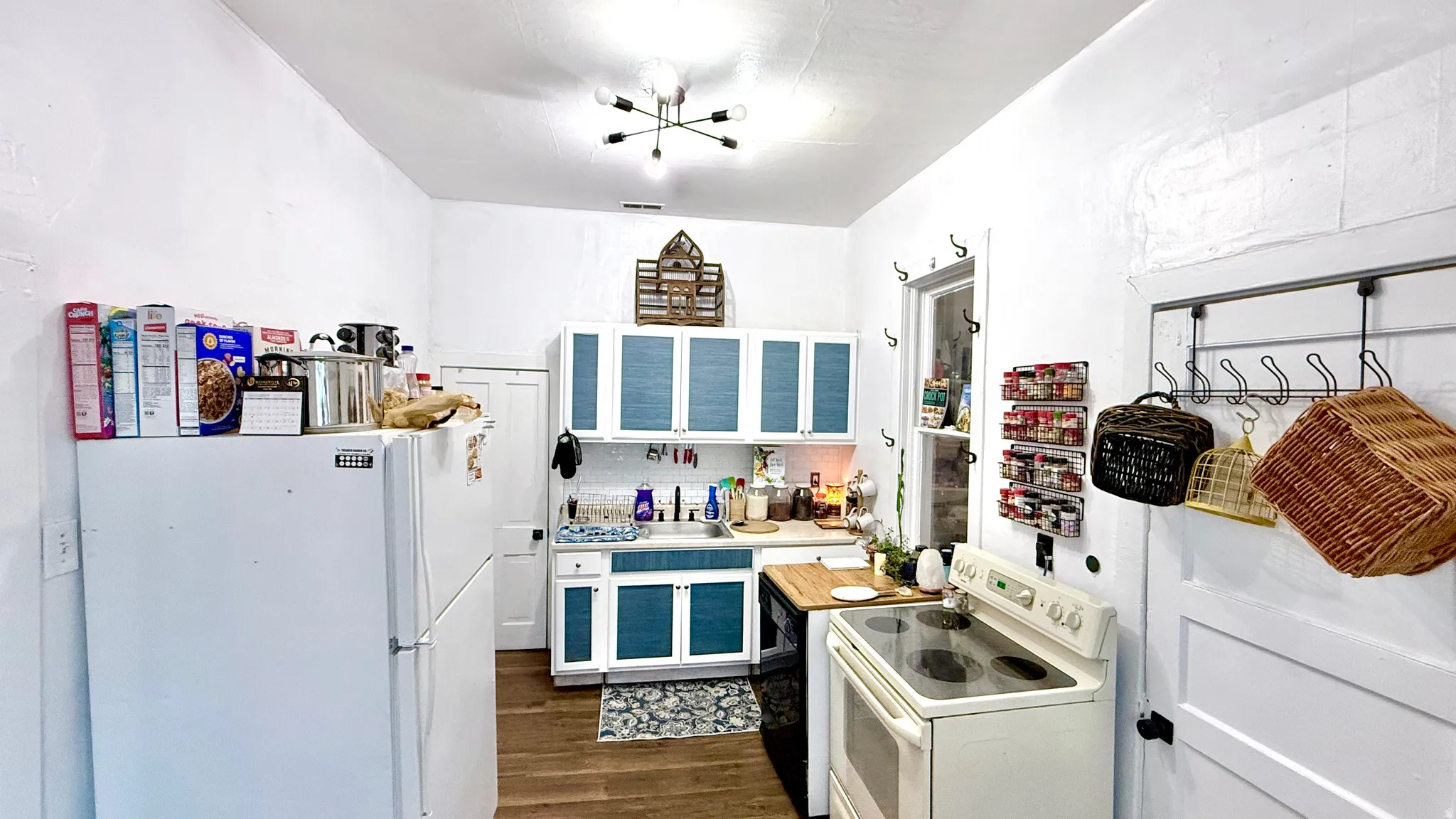 Bright kitchen featuring white walls and wood-finish flooring