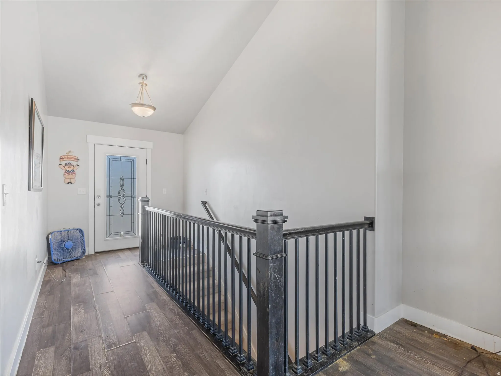 Vaulted ceiling entry with wood-finish flooring