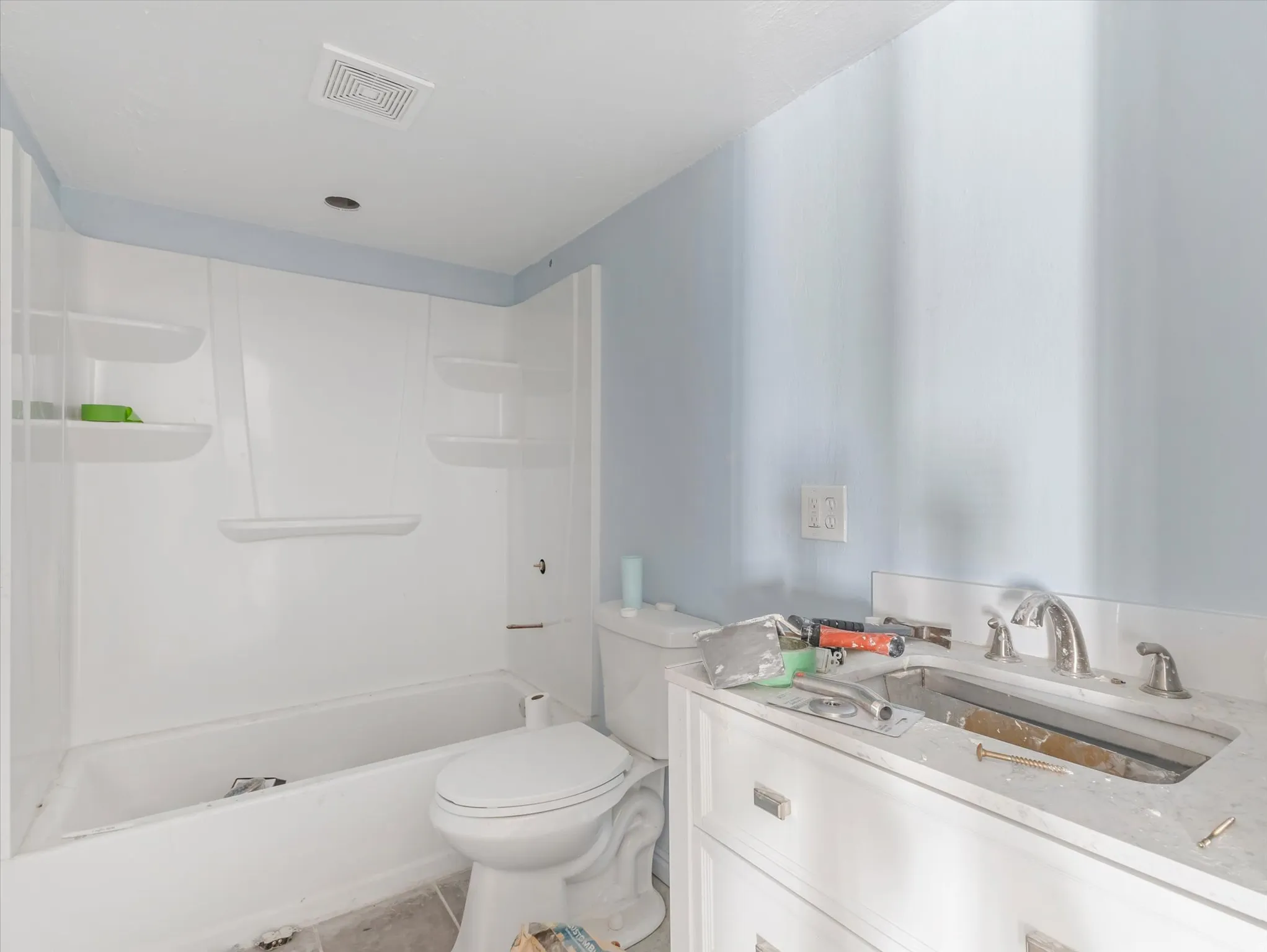 White vanity with a neutral countertop and chrome fixtures