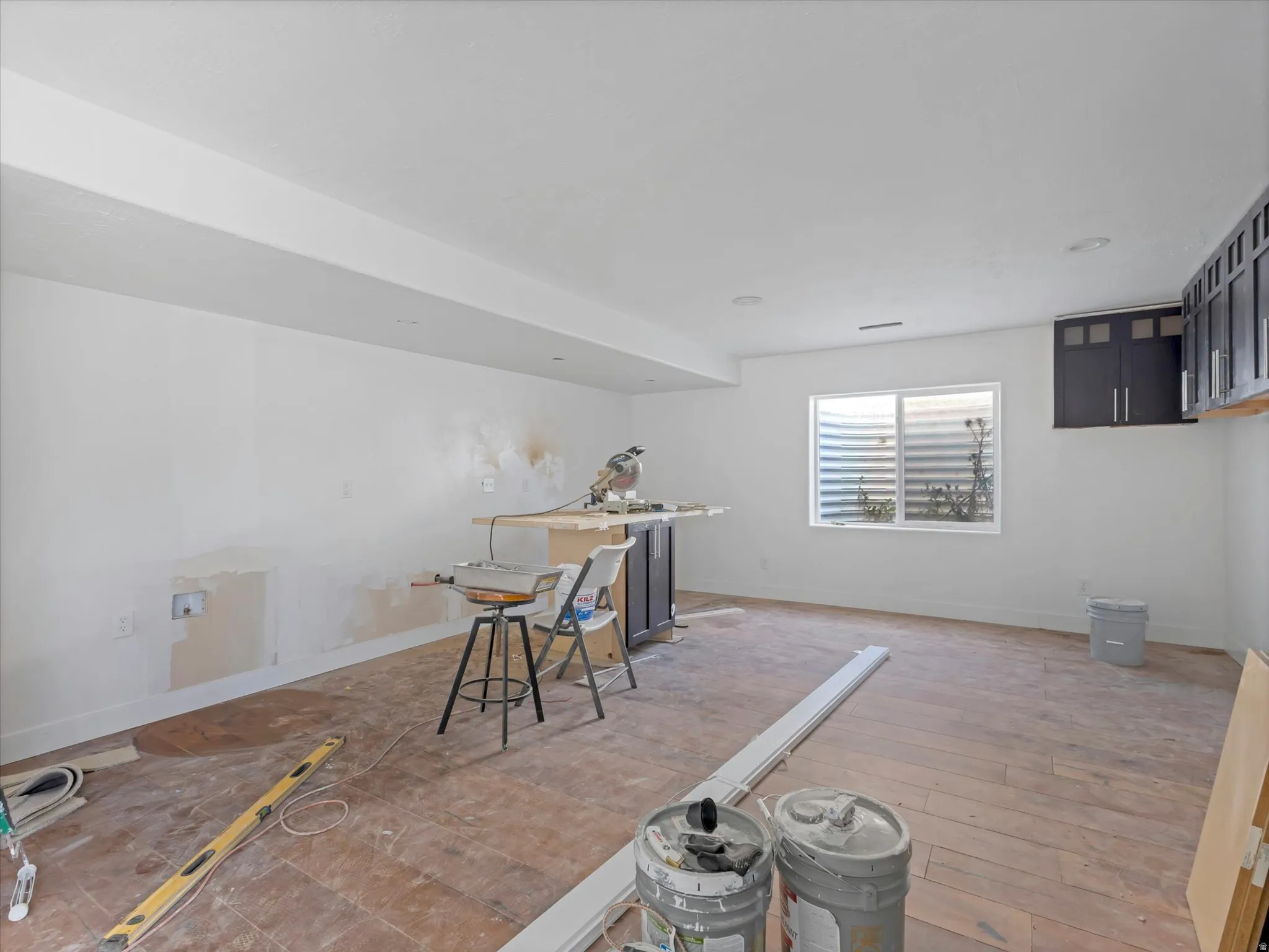 Spacious room featuring light-toned walls, recessed lighting, and a large window with a built-in window well