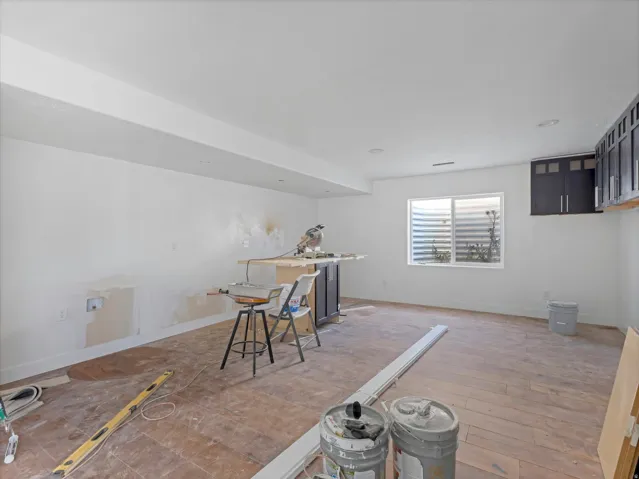 Spacious room featuring light-toned walls, recessed lighting, and a large window with a built-in window well