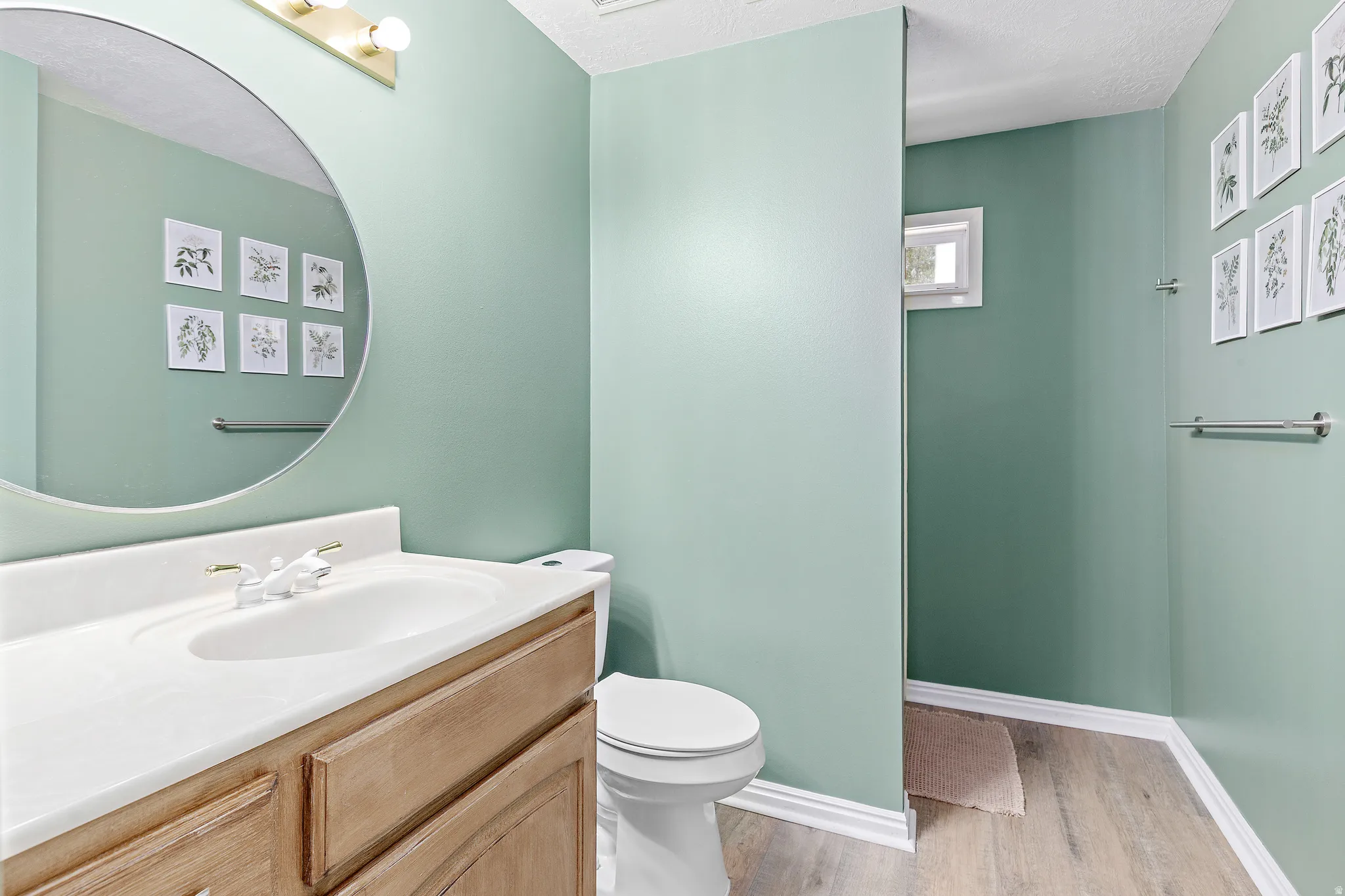 Bathroom featuring a light wood-finish vanity with a white countertop and integrated sink