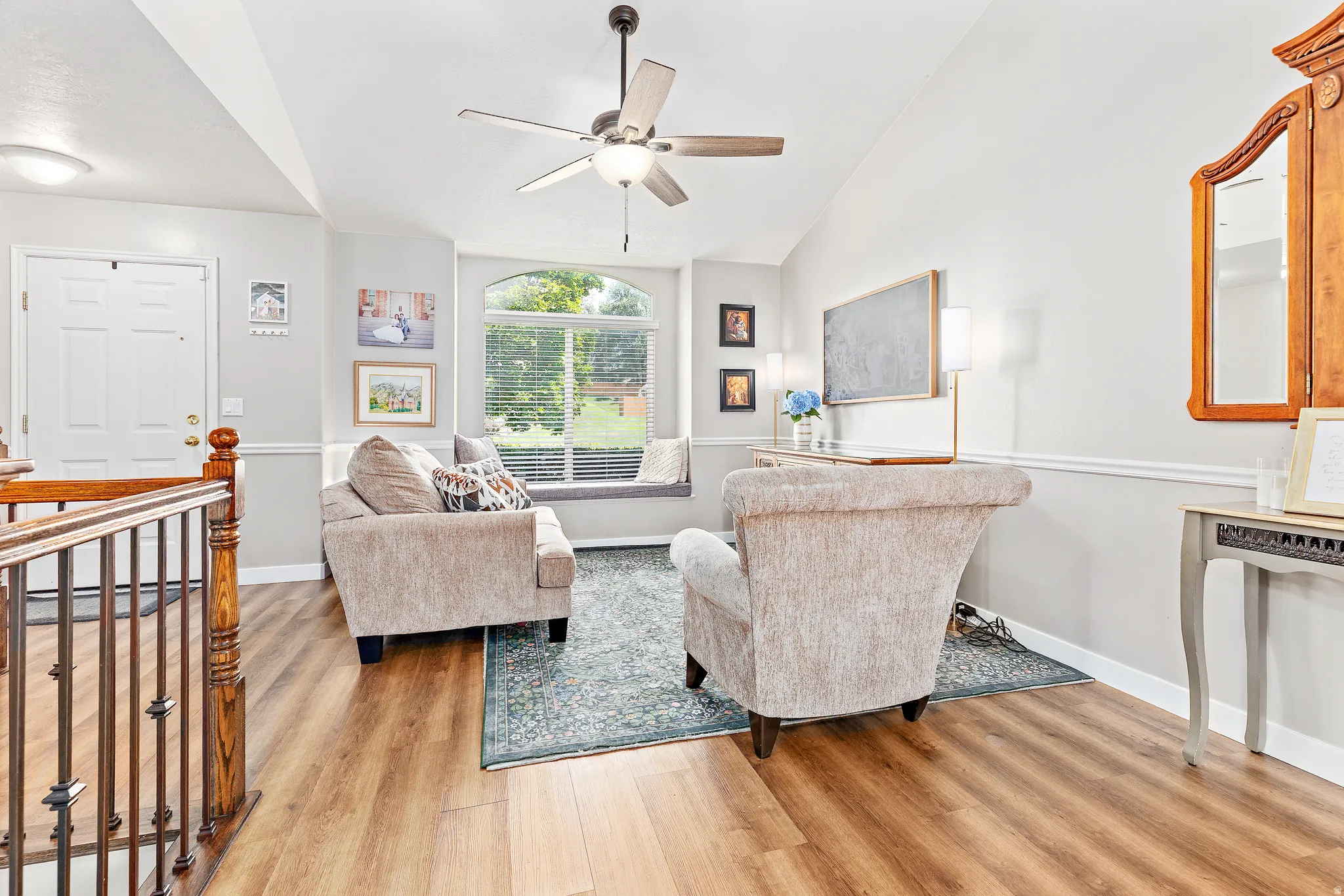 Living space featuring wood-finish flooring, vaulted ceilings, and a built-in window seat