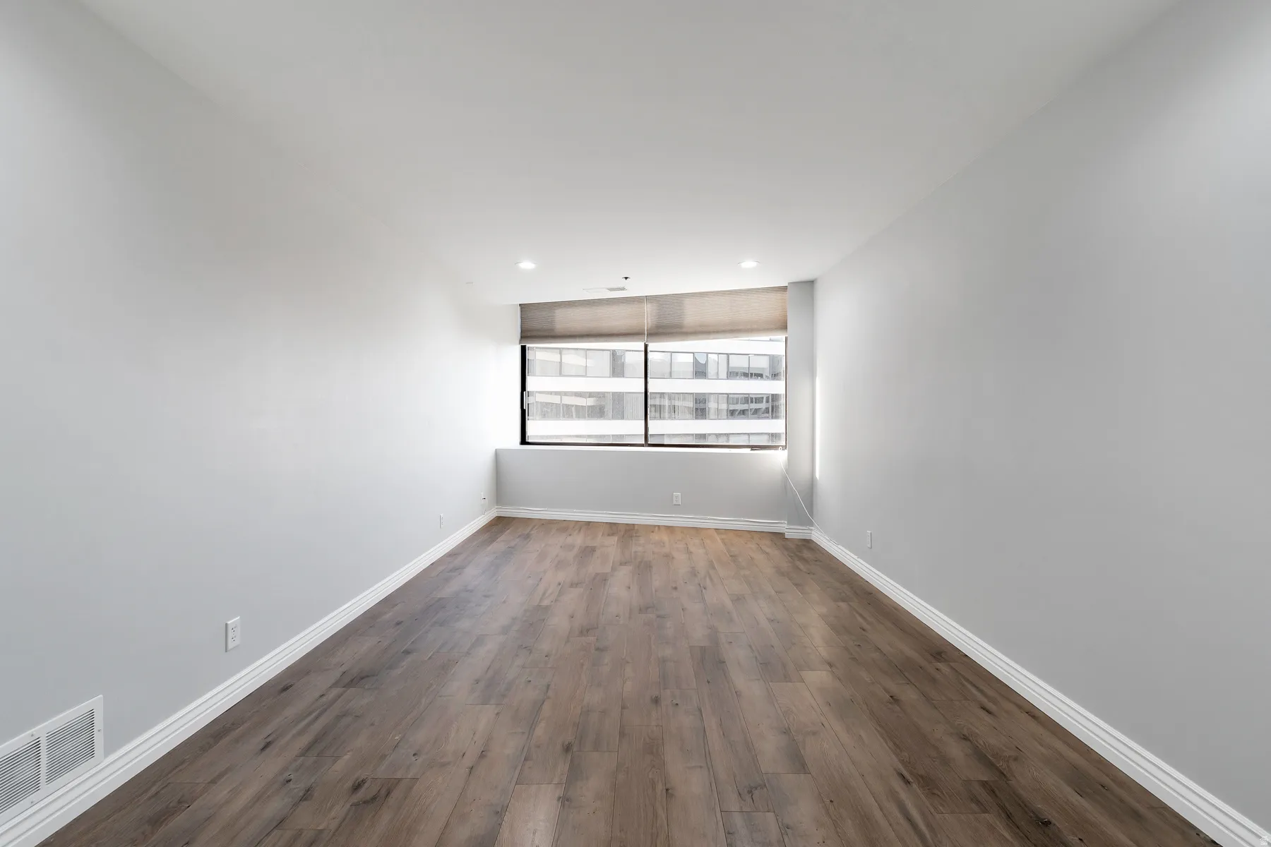 Spacious primary bedroom with laminate flooring