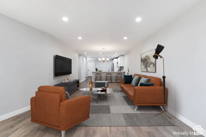 Open-concept living area featuring laminate flooring, recessed lighting