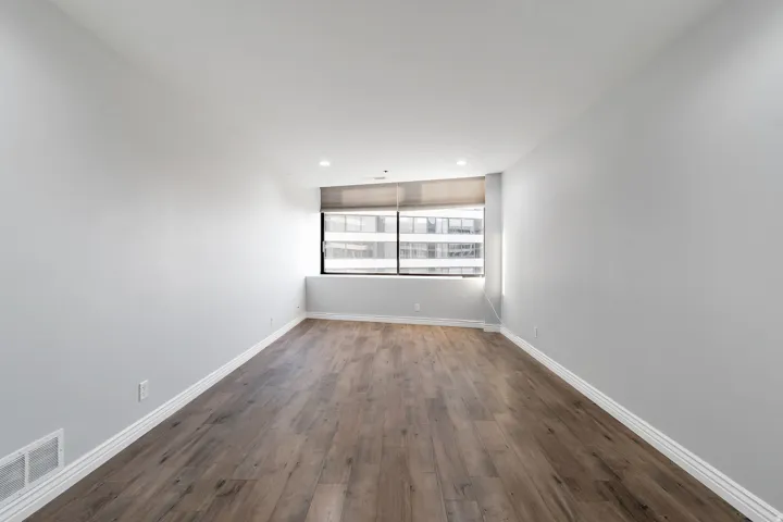 Spacious primary bedroom with laminate flooring