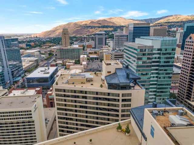 Urban cityscape featuring multiple high-rise buildings and distant mountain ranges
