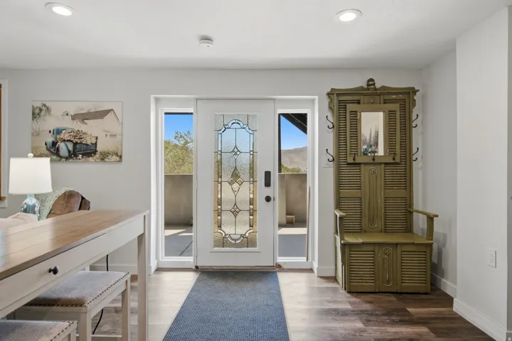 Entryway featuring a decorative glass panel door, two sidelight windows, recessed lighting, and wood-finish flooring