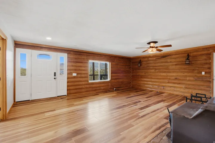 Spacious interior with natural wood-finish flooring and log-style wall paneling