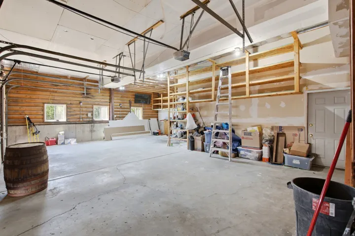 Spacious garage featuring concrete flooring and a wood-paneled wall