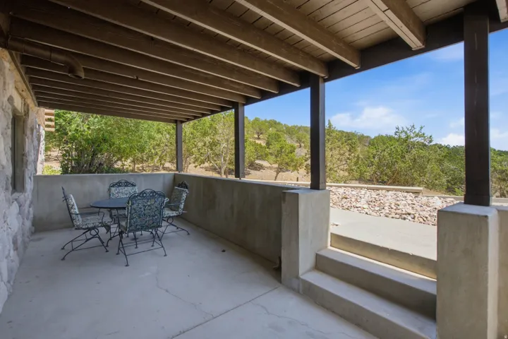 Covered concrete patio featuring exposed wood beam ceiling