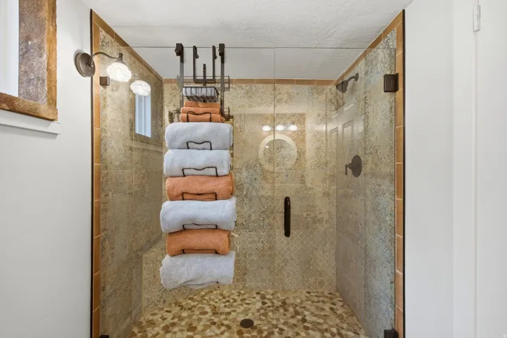 Frameless glass shower enclosure with bronze hardware
