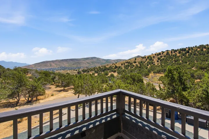 Outdoor deck featuring a dark wood-tone railing and mountain scenery