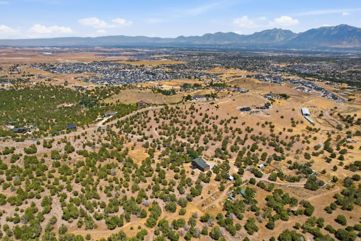 Expansive land parcel featuring diverse topography, extensive natural shrubbery, and distant mountain ranges