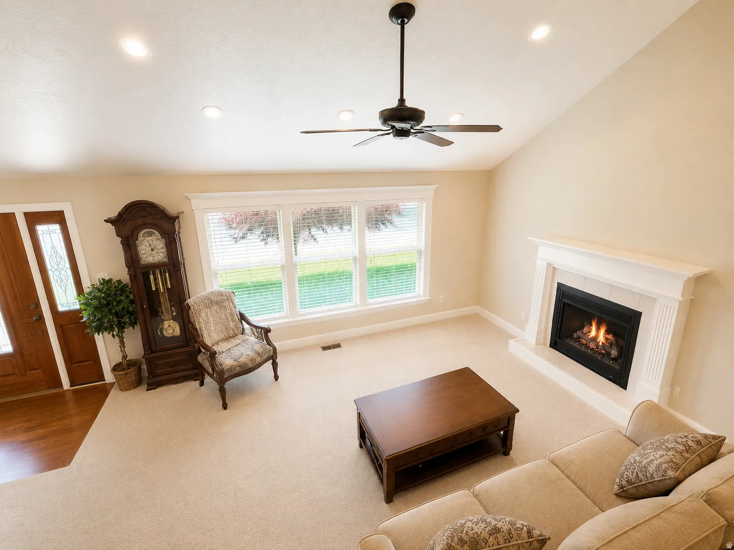 Living area with vaulted ceiling, recessed lighting, and a ceiling fan