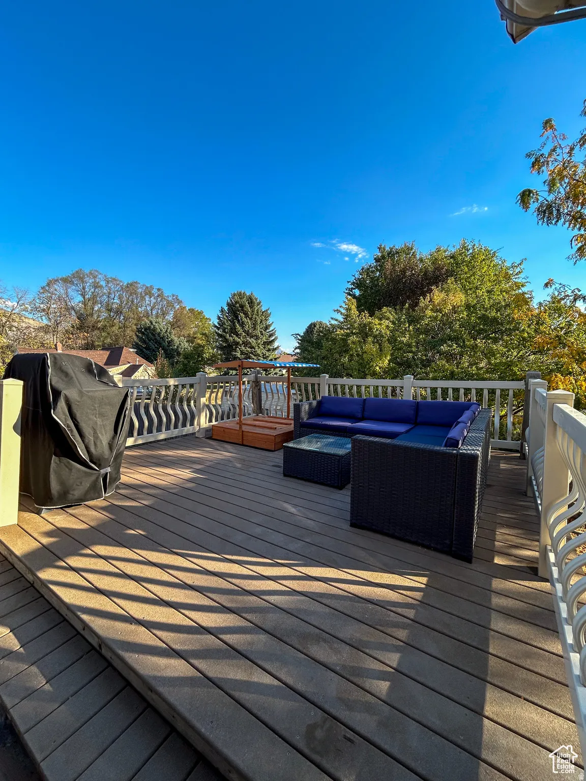 Multi-level composite deck with white decorative railings and steps