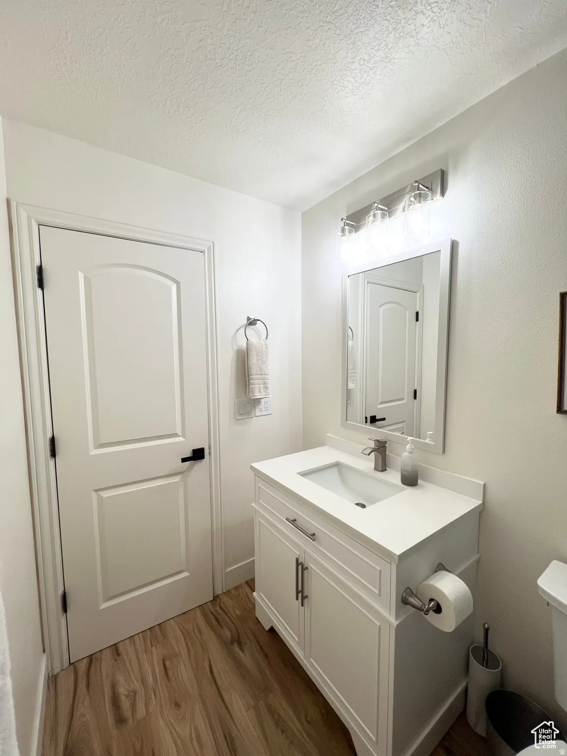White vanity with an integrated rectangular sink, brushed nickel faucet, and coordinating hardware