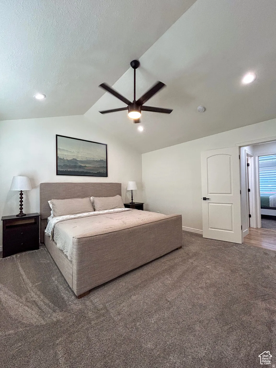 Spacious bedroom with vaulted ceilings, recessed lighting, a ceiling fan, and plush carpeting