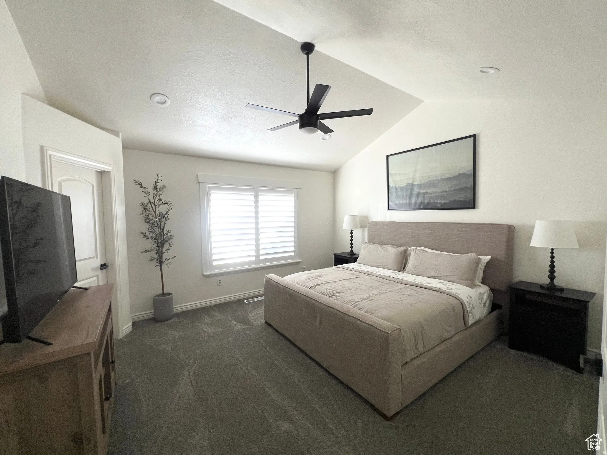 Vaulted ceilings featuring a ceiling fan with light fixture
