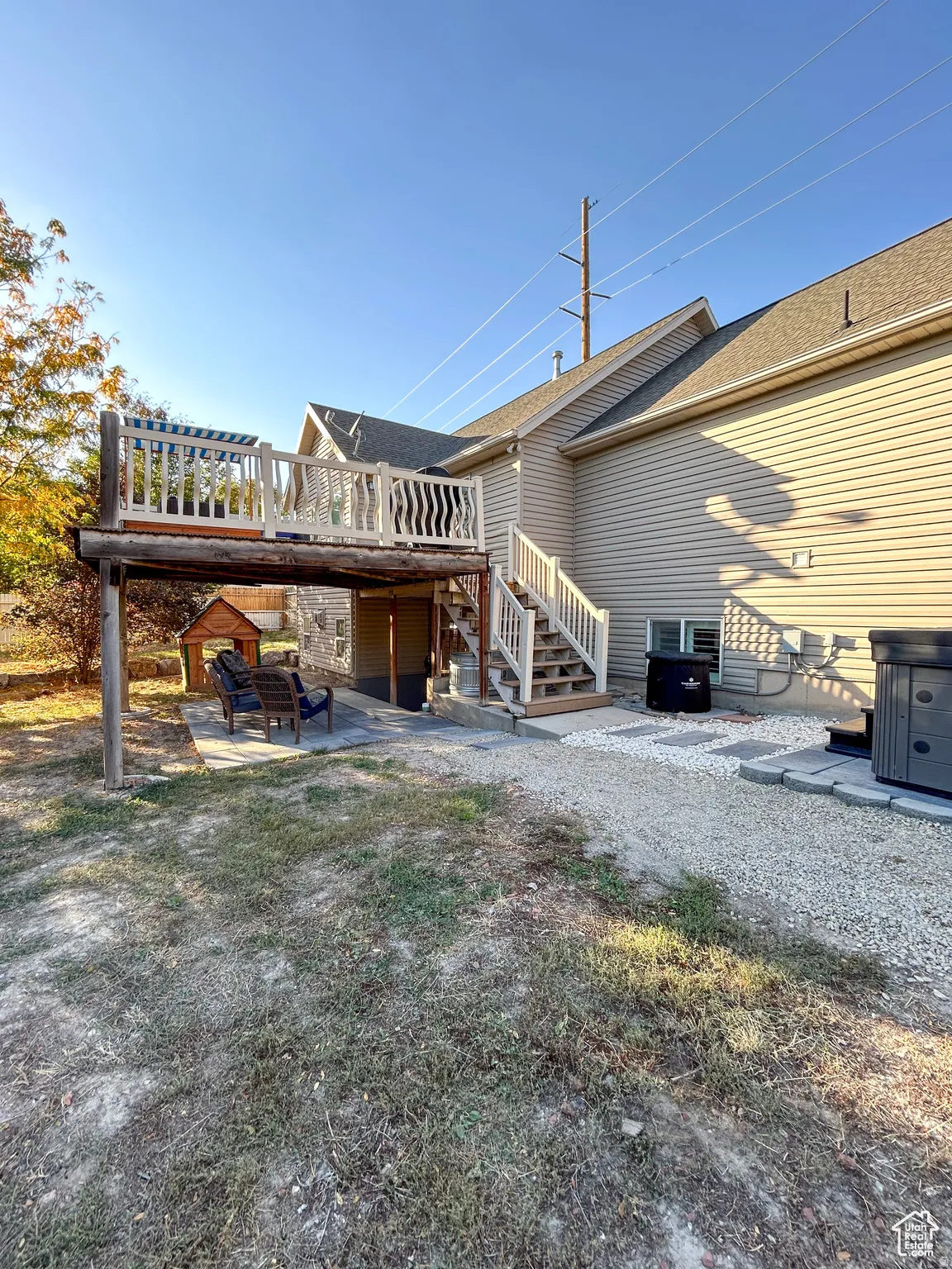 Multi-level deck with white railing, featuring a lower patio area with paving stones