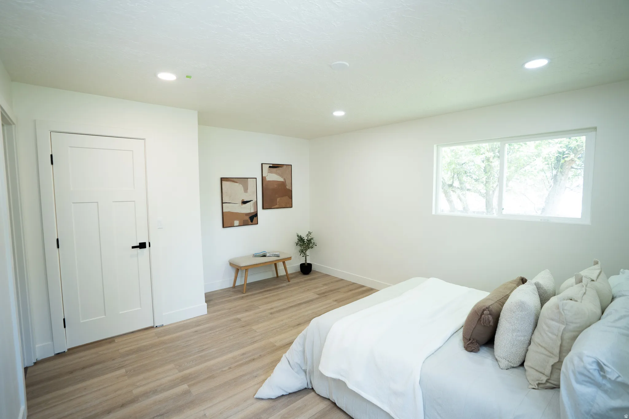Spacious room featuring light wood-finish flooring and a large window