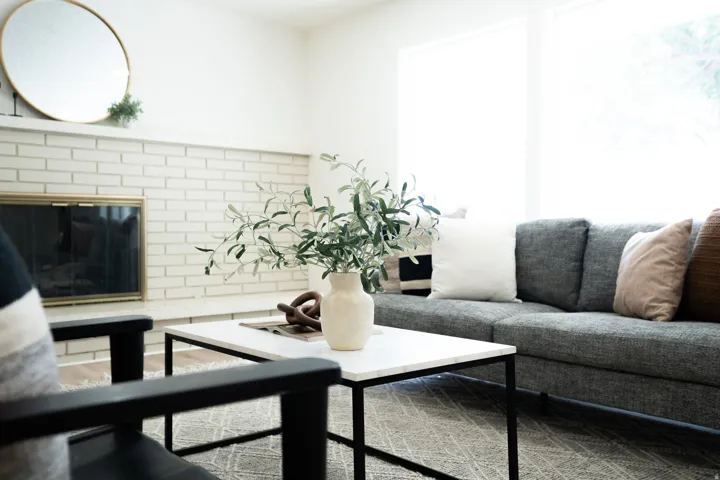 Living area featuring a white brick fireplace with a brass fire screen and a white mantel