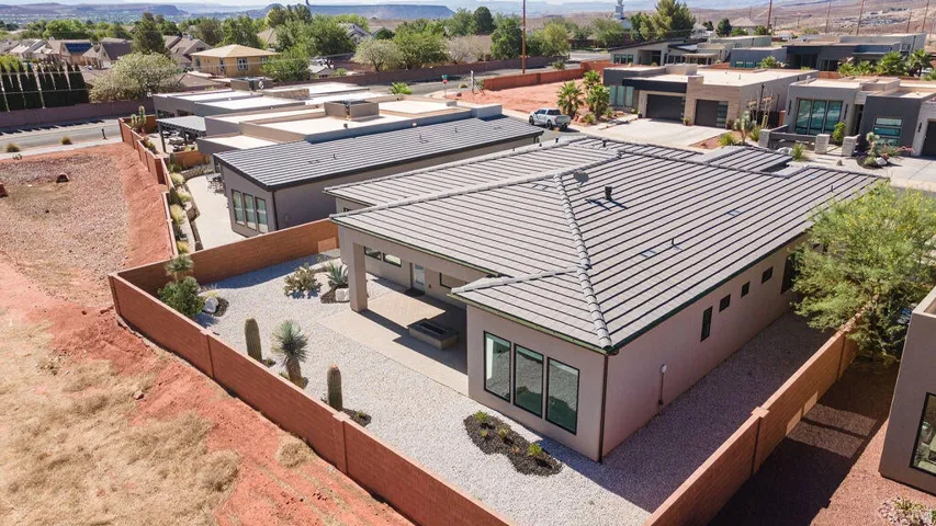 Contemporary-style residence featuring a multi-level tile roof, stucco exterior, and large windows