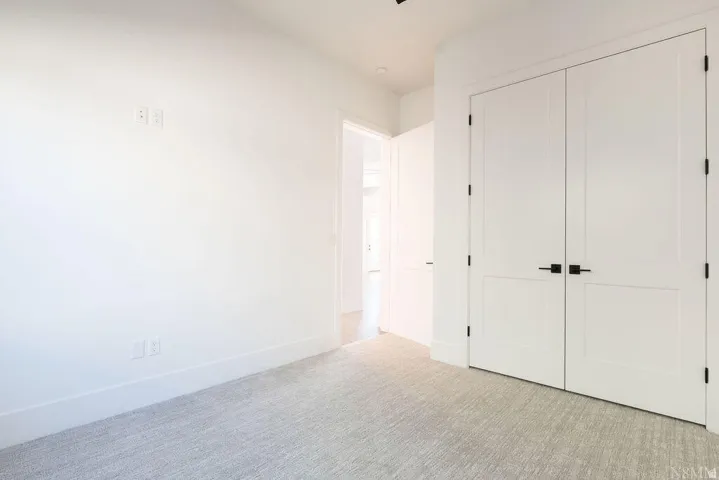 Neutral-toned carpet flooring complementing white walls and baseboards