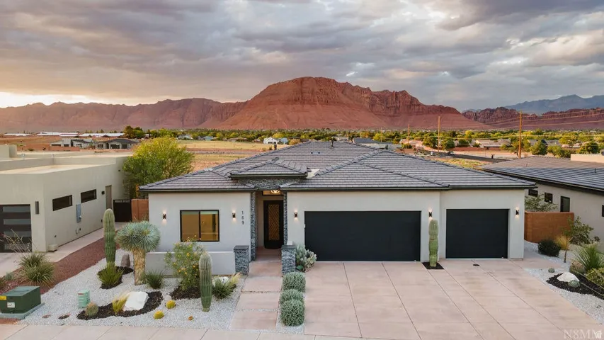 Contemporary facade featuring a stucco exterior, stone accents, and a tiled roof