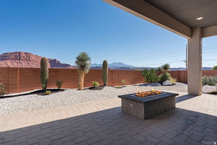 Covered patio with paver flooring and a built-in fire pit