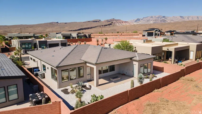 Modern desert landscape home featuring a covered patio, integrated fire pit, and low-maintenance xeriscape