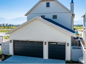 Modern exterior featuring white siding and a two-car garage with dark paneled doors