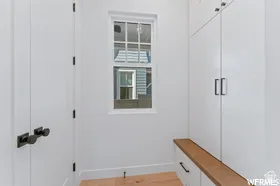 Entryway featuring a single window, built-in storage cabinetry, a wood-finish bench, and wood-finish flooring